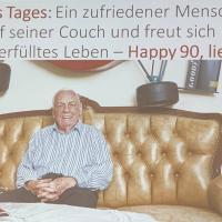 Ein zufriedener Mensch sitzt lächelnd auf seiner Couch und freut sich über sein langes und erfülltes Leben – Happy 90, lieber Kurt!